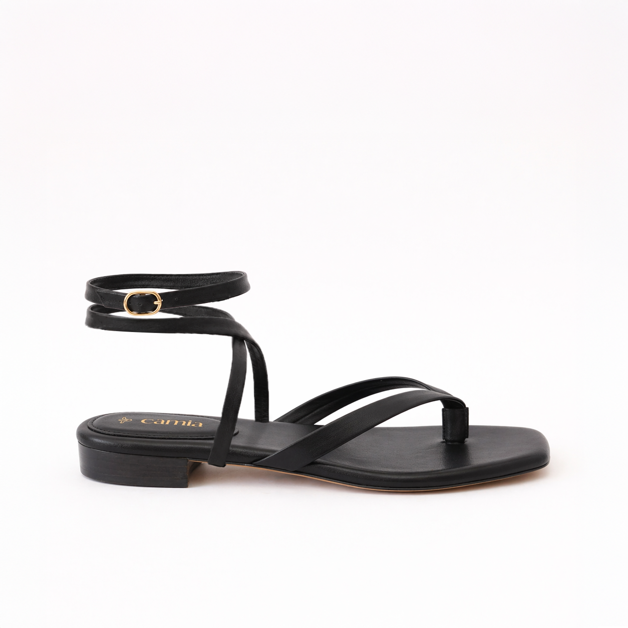 A single flat sandal in a black color, featuring a low block heel, a thong-style toe strap, and an ankle strap with a small gold buckle.